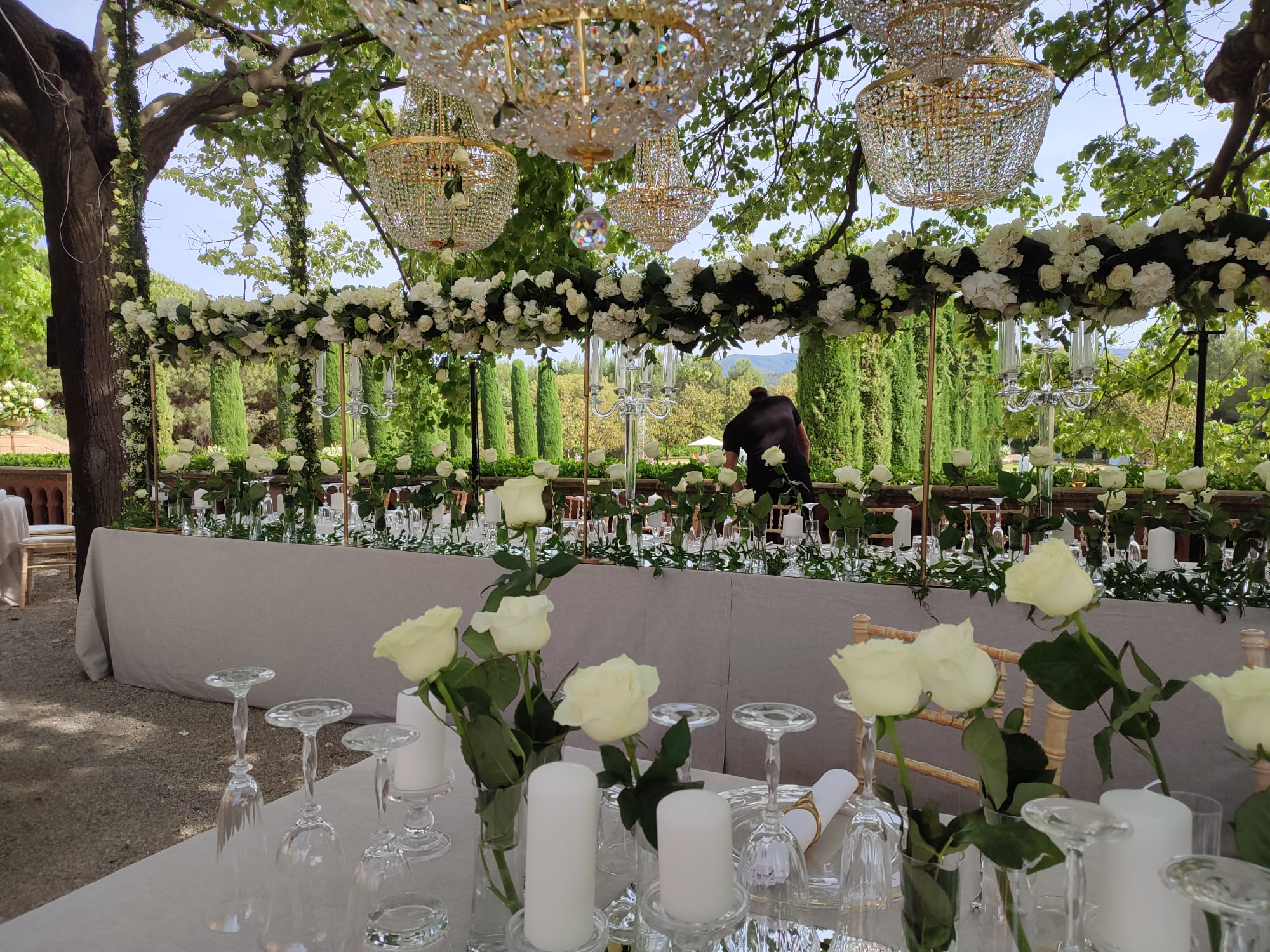 Montaje floral exterior con guirnalda de rosas blancas y arañas de cristal - Barcelona