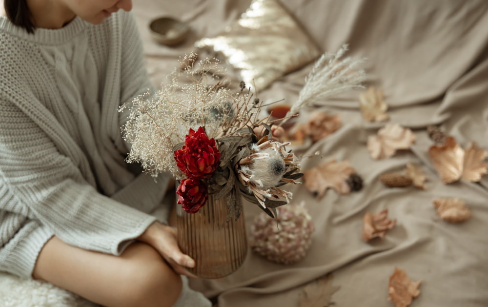 mujer decorando con flores secas