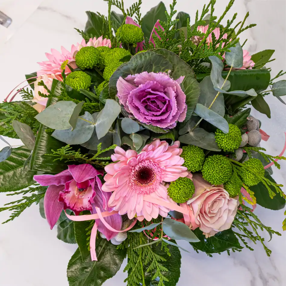 Base de cristal con gerberas, cymbidium, rosas, botón verde, safari y brasica