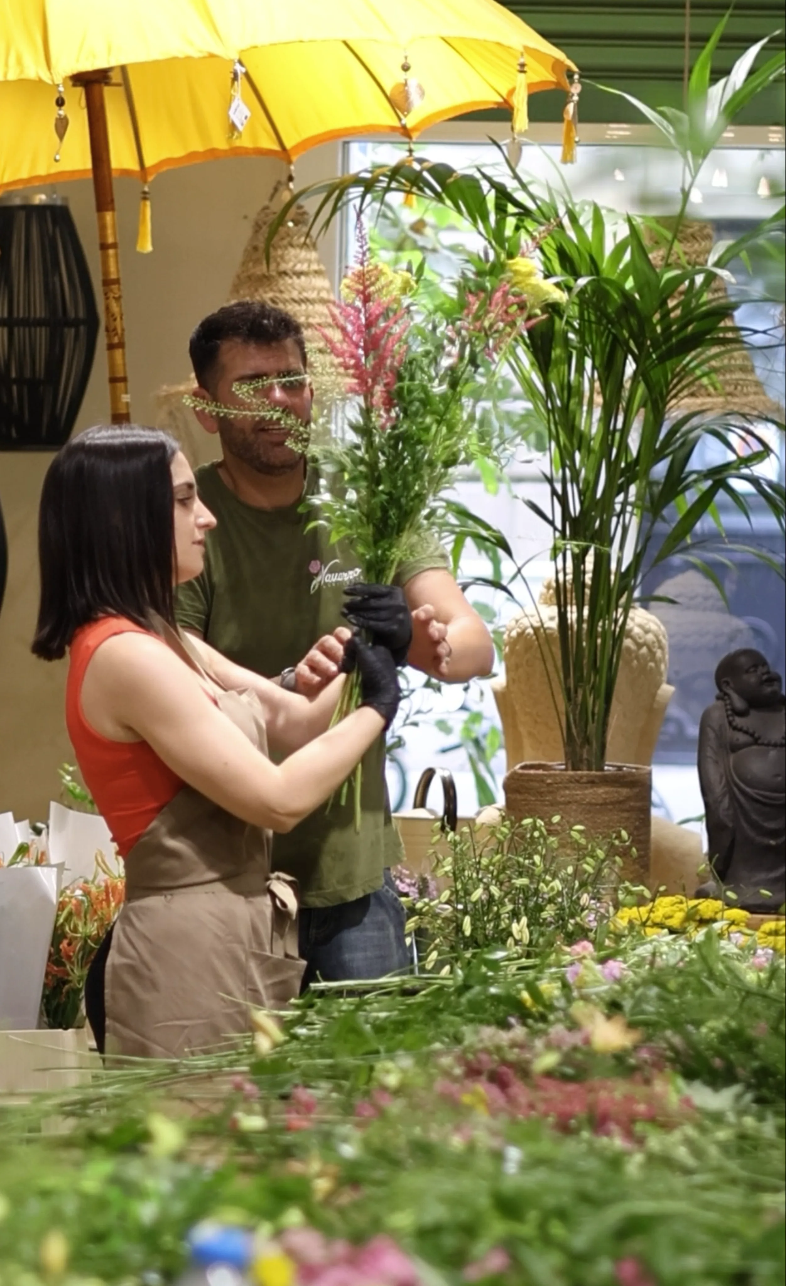 Dos personas preparando una composición floral durante un taller