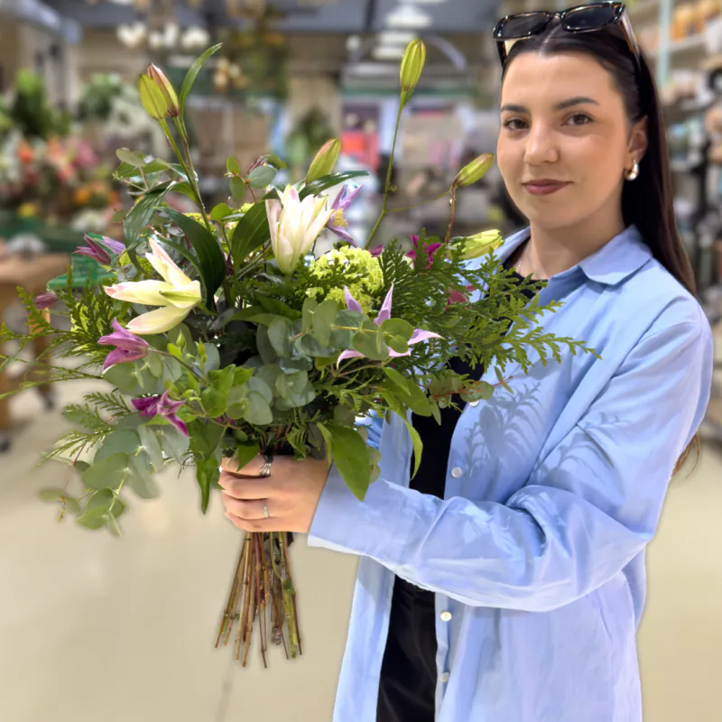 Alumna con un ramo de lilium blanco, helechos y eucalipto
