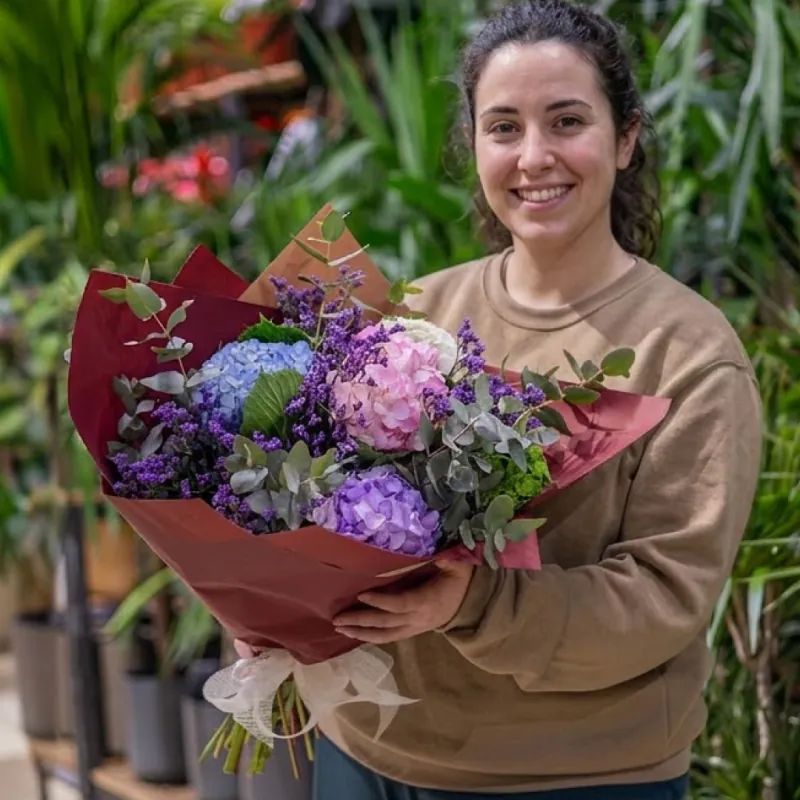 Ramo de hortensias moradas y lilas envuelto en papel granate